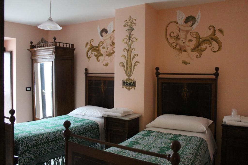 a bedroom with two beds and a window at La Dimora di Ziella in Barisciano