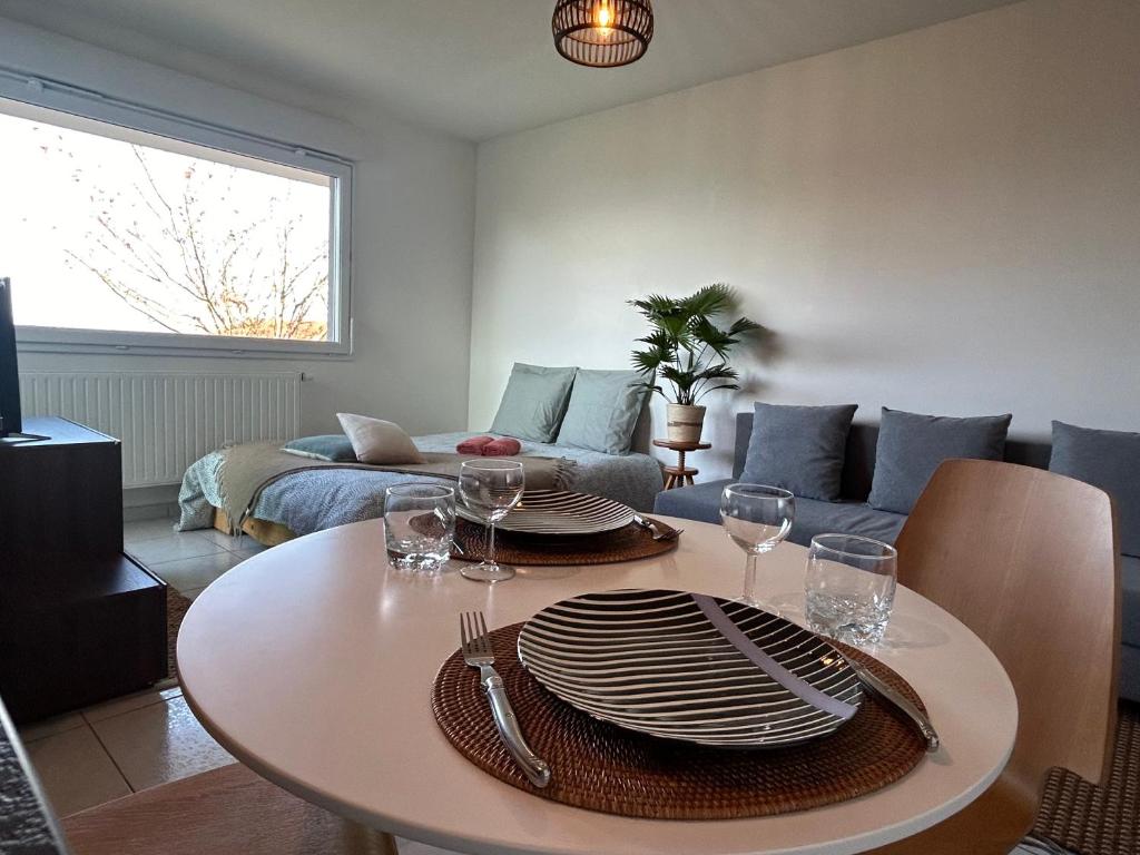 - un salon doté d'une table avec des assiettes et des verres à vin dans l'établissement Jolie vue au calme, à Évian-les-Bains