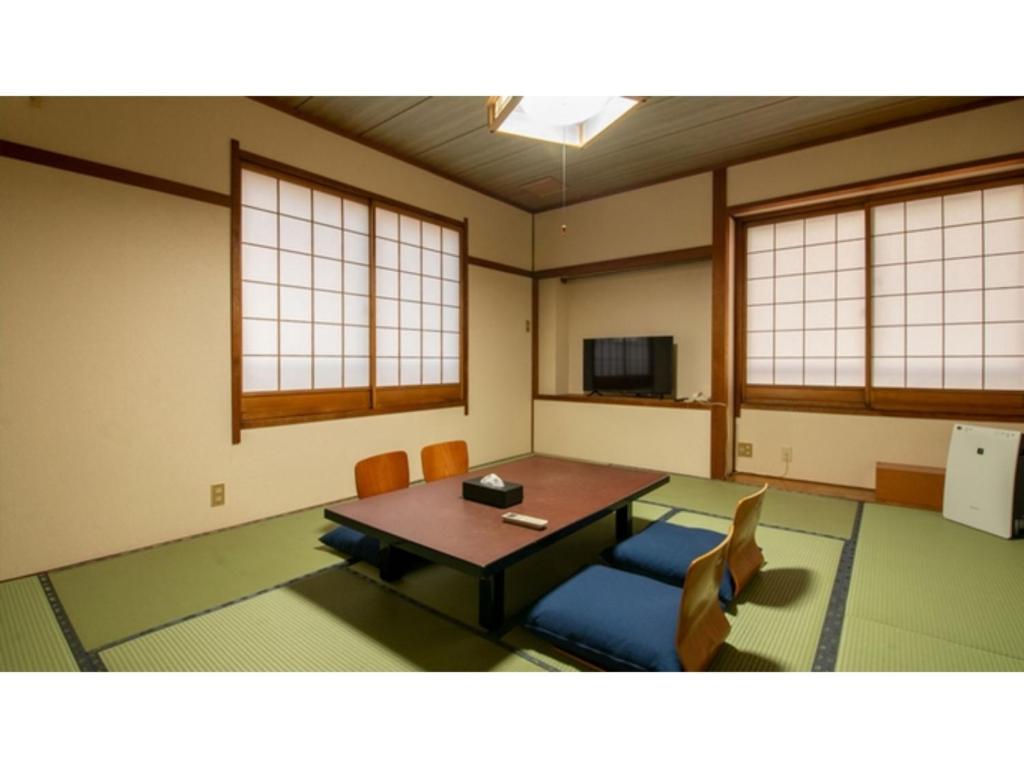 Cette chambre comprend une table, des chaises et des fenêtres. dans l'établissement Taiheian - Vacation STAY 57433v, à Sakai