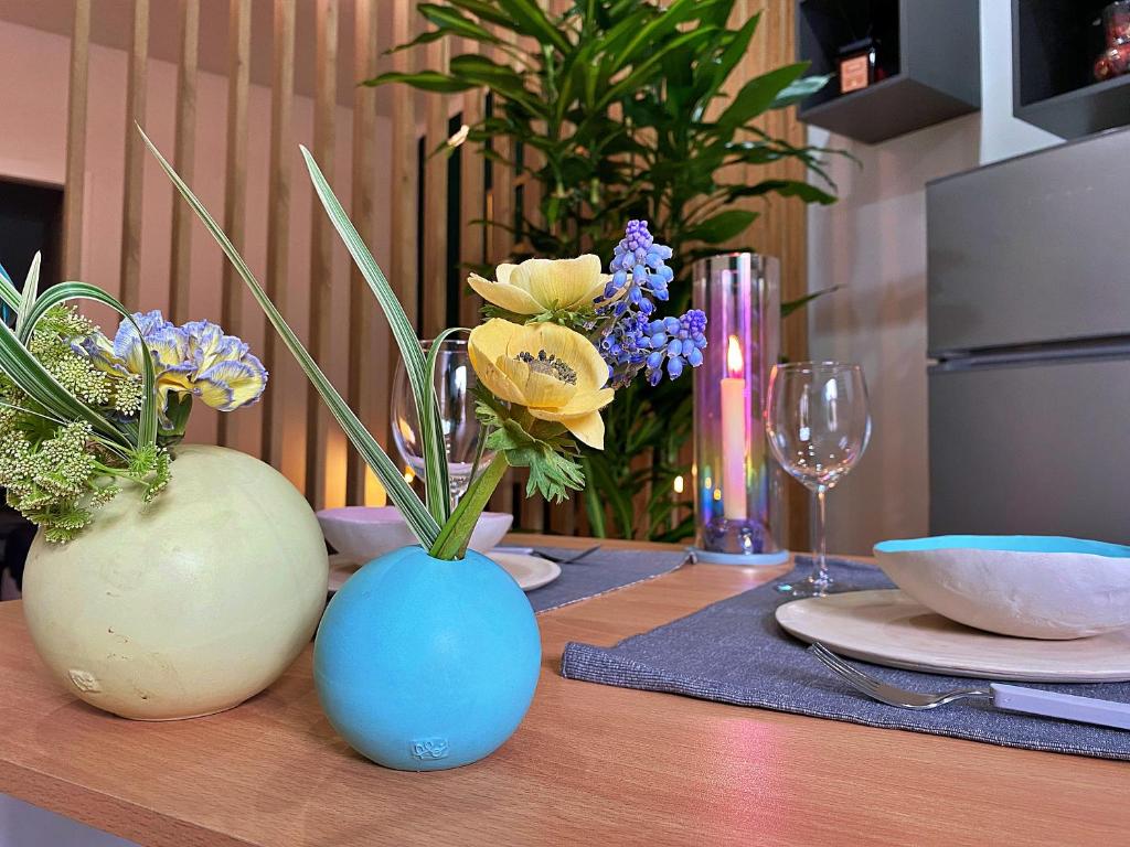 uma mesa com dois vasos cheios de flores em [FIERA] Bologna Expo Home em Bolonha