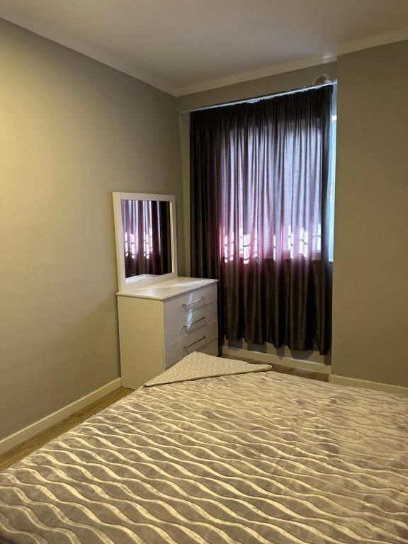 an empty room with a dresser and a window at Luxury apartment in the calmest area in Tirana