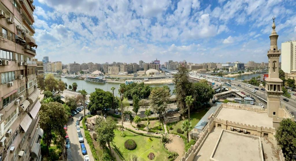 een uitzicht op een stad met een rivier en een klokkentoren bij Zamalek X Hostel in Caïro