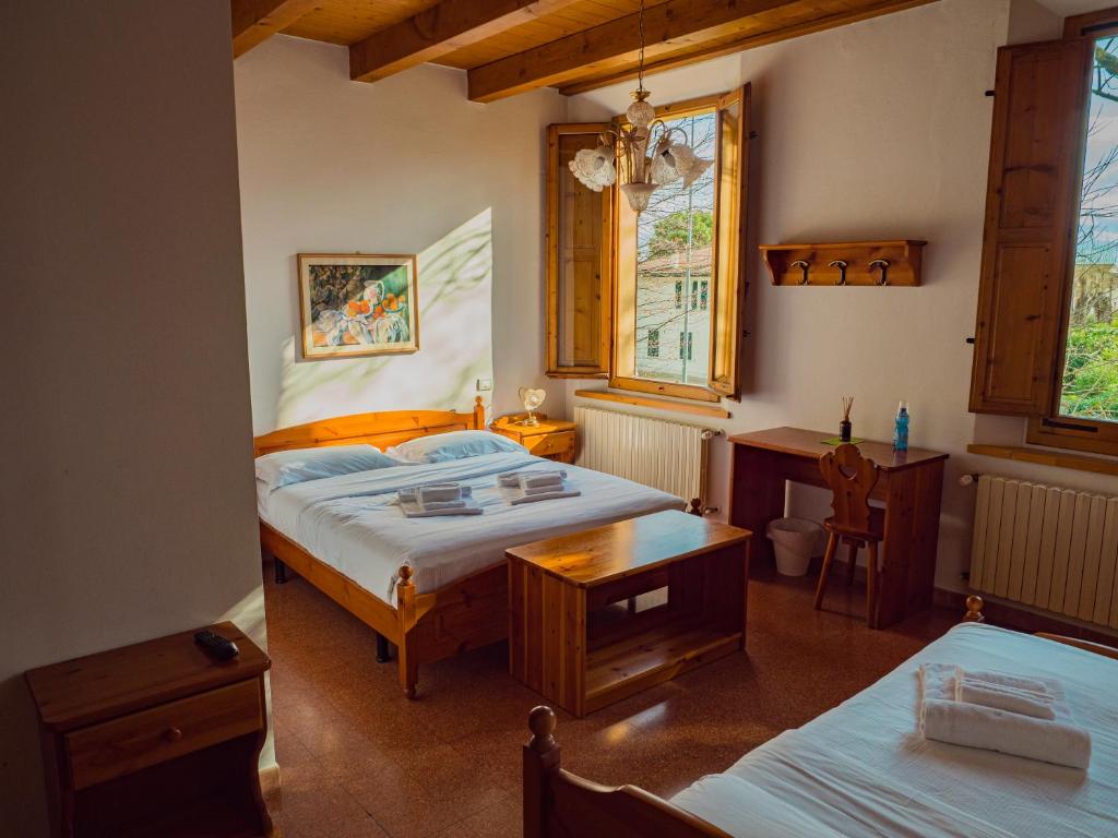 una camera con 2 letti, una scrivania e finestre di B&B Villa Erika a Villa San Martino