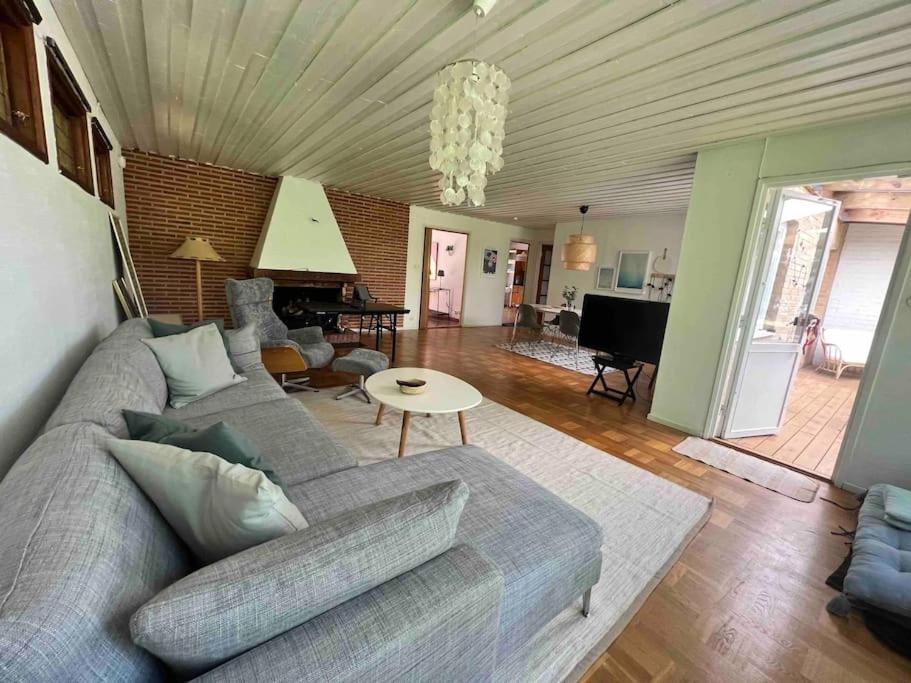 uma sala de estar com um sofá cinzento e uma mesa em Cozy house near the sea em Höllviken