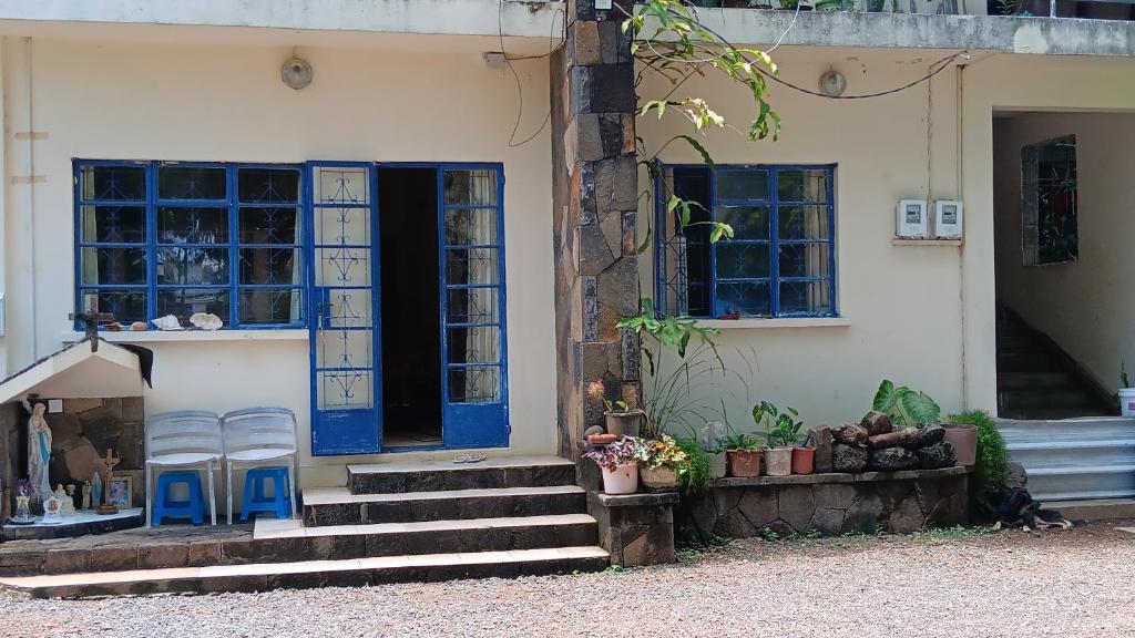two chairs sitting outside of a house with blue doors at Chez Leone in Grand Baie