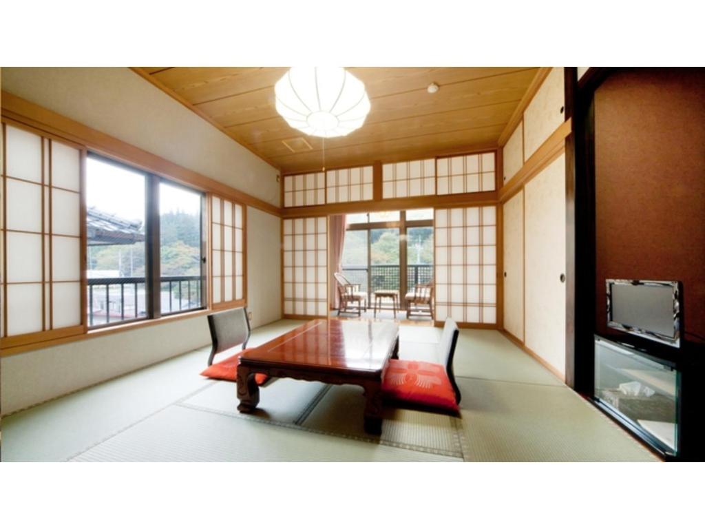 四万にあるShimaonsen AYAMEYA Ryokan - Vacation STAY 20622vのテーブルと椅子、窓が備わる客室です。