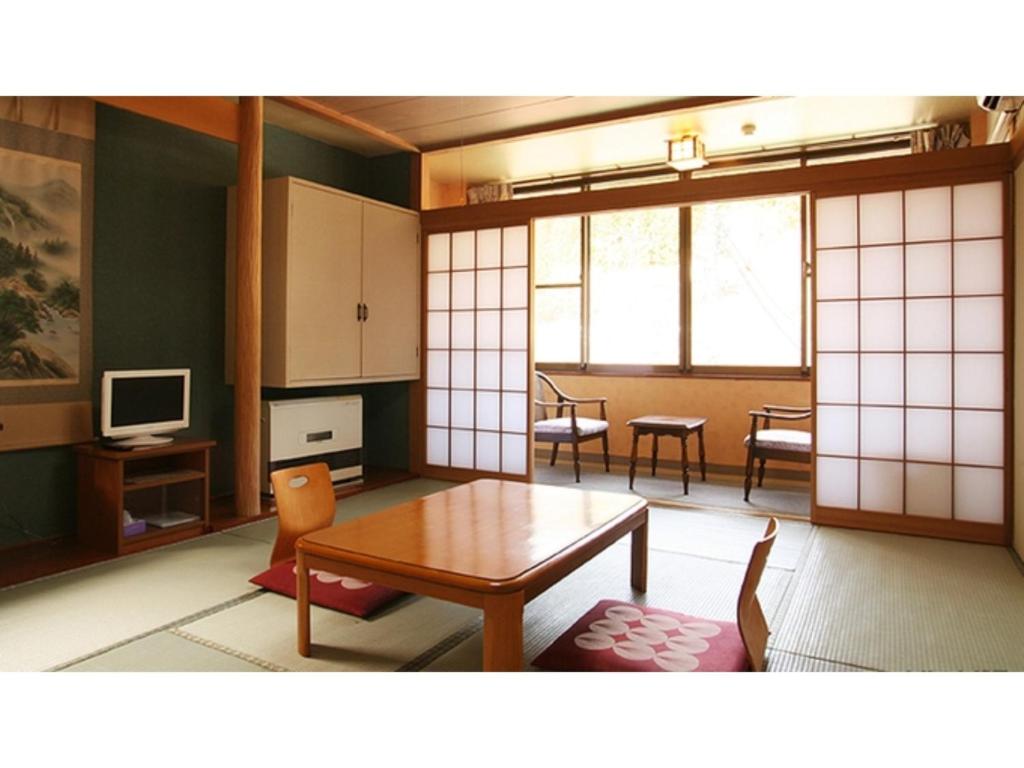 un soggiorno con tavolo e una sala da pranzo di Shimaonsen AYAMEYA Ryokan - Vacation STAY 20611v a Shima