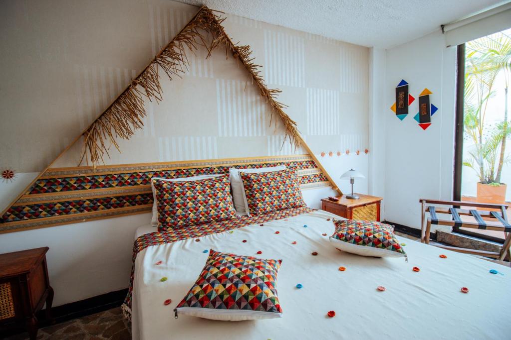 1 dormitorio con 1 cama grande y cabecero triangular en Hotel Zandu en Pereira