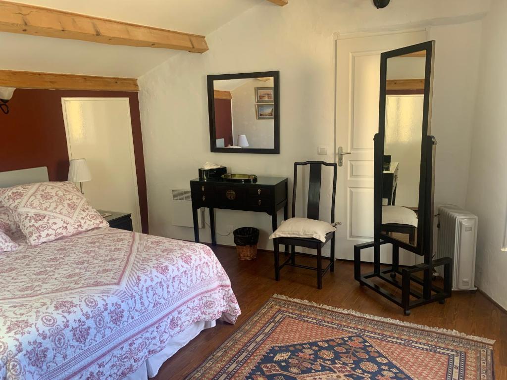 MagalasにあるComfortable Gite (3) in attractive Languedoc villageのベッドルーム(ベッド1台、デスク、鏡付)