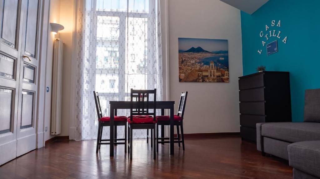 un soggiorno con tavolo da pranzo e sedie di Casa Latilla a Napoli