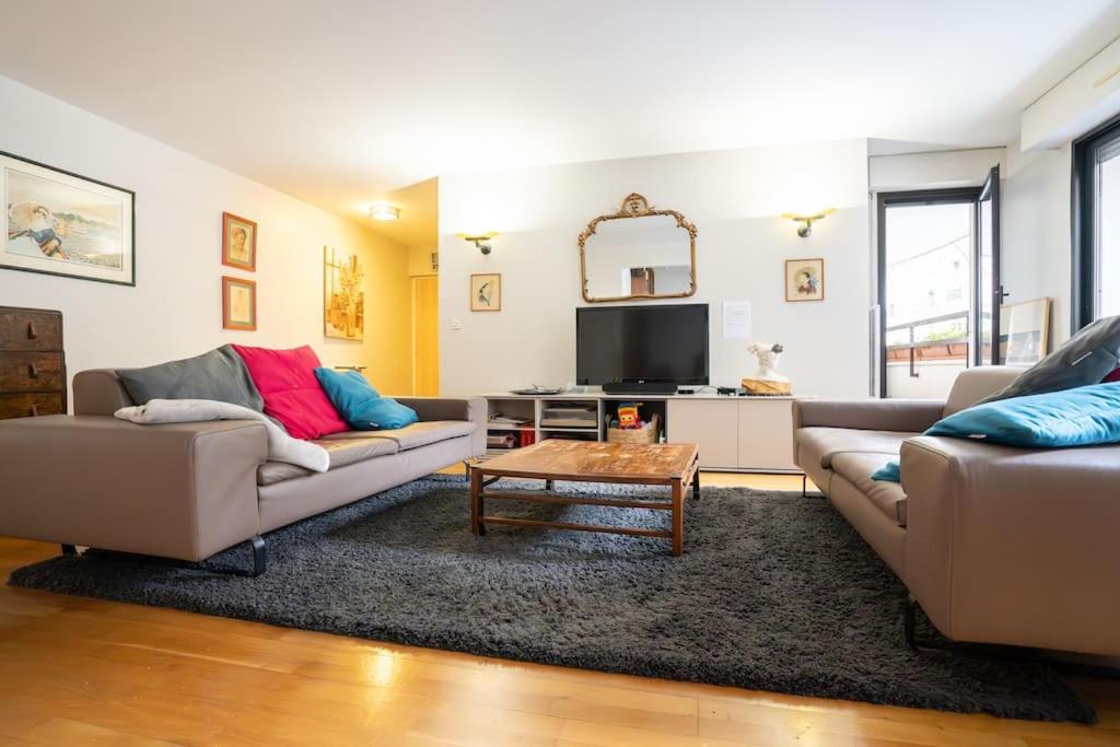 un salon avec deux canapés et une table basse dans l'établissement Julian's house charmant 3 pièces, à Levallois-Perret