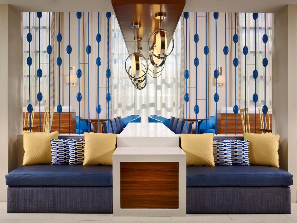 a living room with a blue couch and a chandelier at Parsippany Suites Hotel in Parsippany