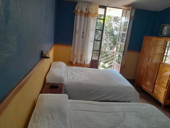 1 Schlafzimmer mit 2 Betten und einem Fenster in der Unterkunft Posada Rincon Campirano in Zacatlán