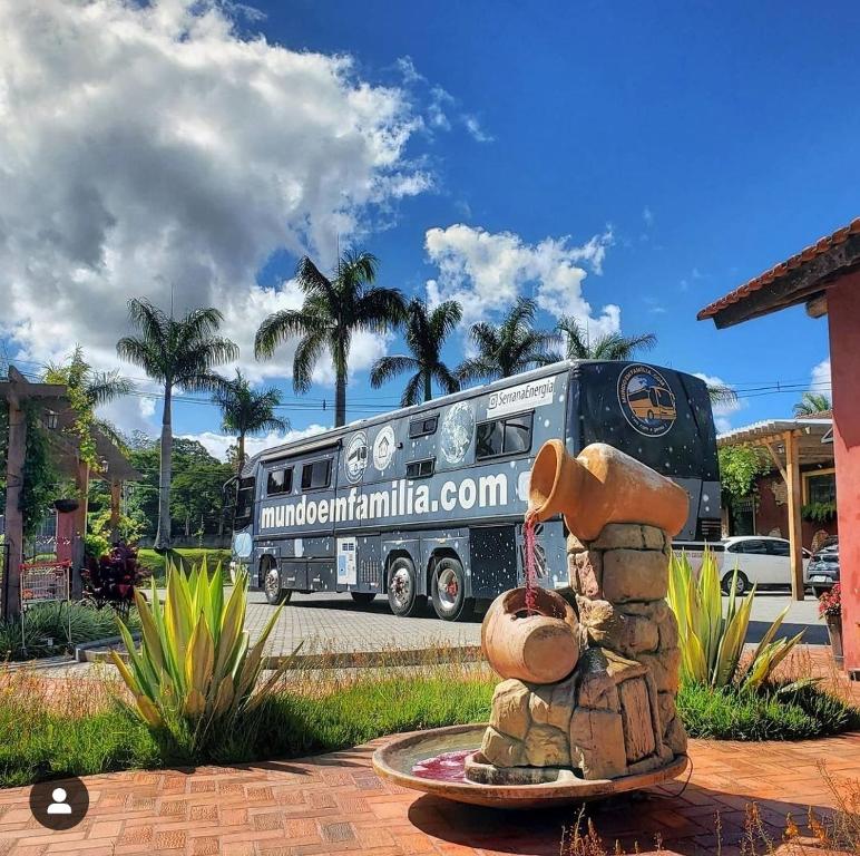 a bus is parked next to a statue of a bear at Experiência num Luxuoso Motorhome in São Roque