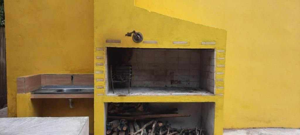 - un bâtiment jaune avec une cuisine équipée d'un évier dans l'établissement Casa da Vigia, à Santana do Livramento