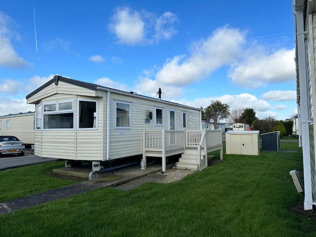 a white mobile home parked in a yard at D34 Steeple Bay Caravan Site in Chelmsford
