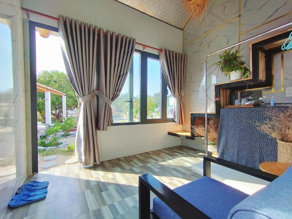 a living room with a couch and a window at Mơ Homestay Kê Gà (Mer Bleue Homestay) in Ke Ga