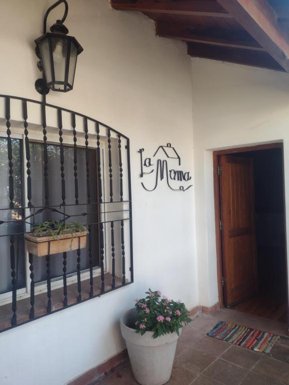 eine weiße Wand mit einem Schild an der Seite eines Gebäudes in der Unterkunft LA MAMA in Mercedes