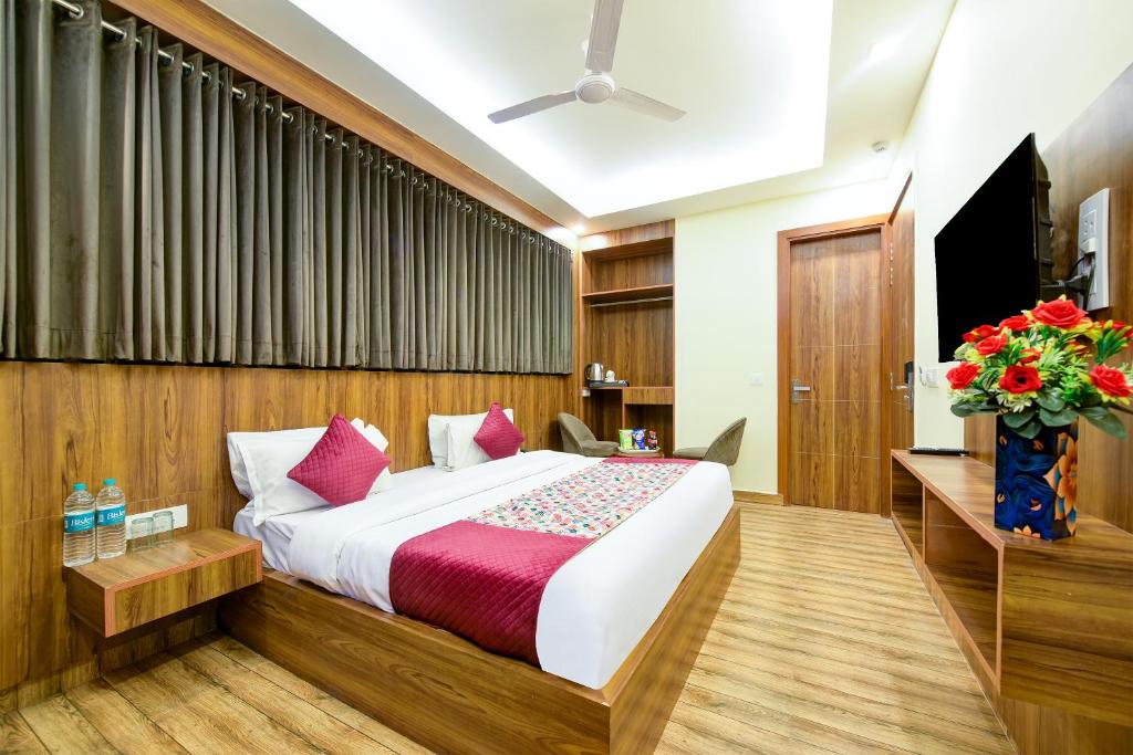 1 dormitorio con 1 cama grande y TV en Roseewood Hotel Near Delhi International Airport en Nueva Delhi