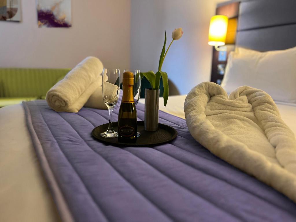 a bed with a table with wine glasses and a heart at Black Iris Hotel in Newport