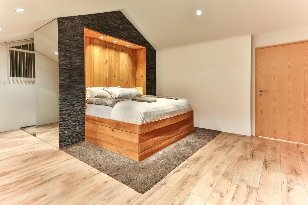 een slaapkamer met een bed met een houten muur bij Villa 10 min from city - perfect for families - Renovated 2024 in Garðabær