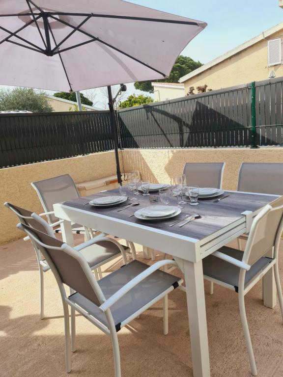 a white table with chairs and an umbrella at tytoun evasion in Borgo