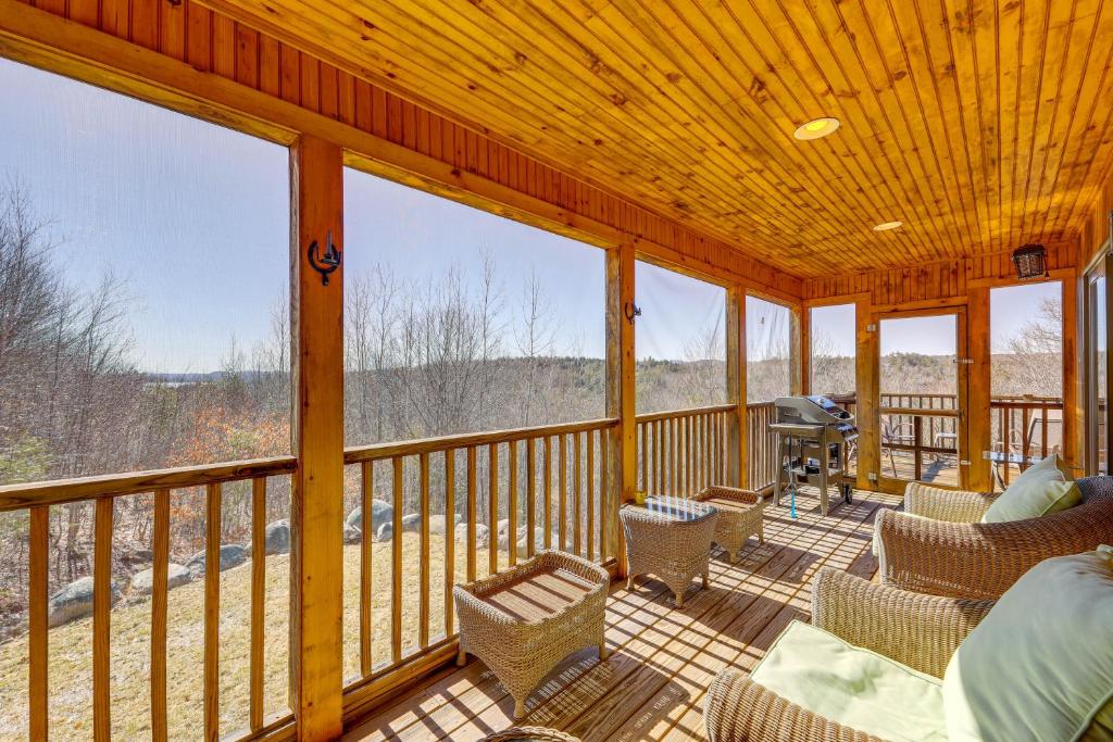 un porche cubierto con sillas y una parrilla en Spacious Harrison Cabin about 1 Mi to Long Lake! en Bridgton