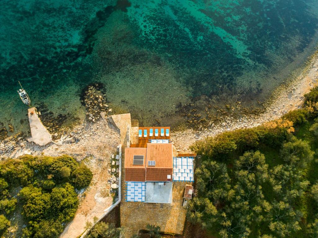une vue aérienne sur une maison à côté de l'eau dans l'établissement Otus, à Kraj