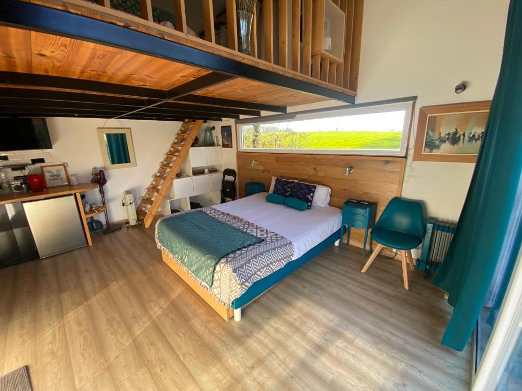um quarto com uma cama e uma grande janela em Petit chalet em Nernier