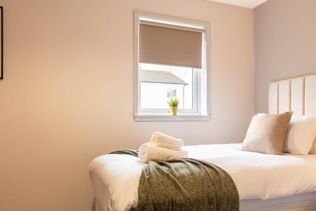 a bedroom with two beds and a window at Grove House in North Queensferry
