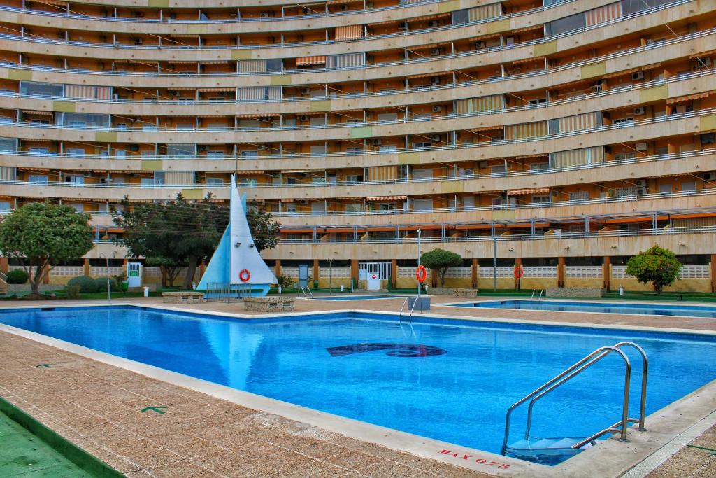una piscina frente a un gran edificio en Calpe apartamento nuevo 1a línea playa piscina, en Calpe