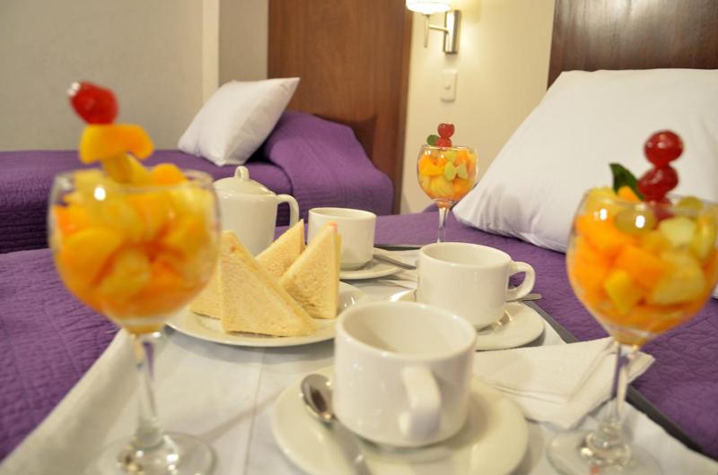 een tafel met een schaal fruit in wijnglazen bij Miculla Hotel in Tacna