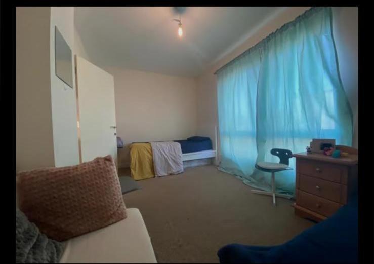 1 dormitorio con 1 cama, vestidor y ventana en Self catered rooms en Thamesmead