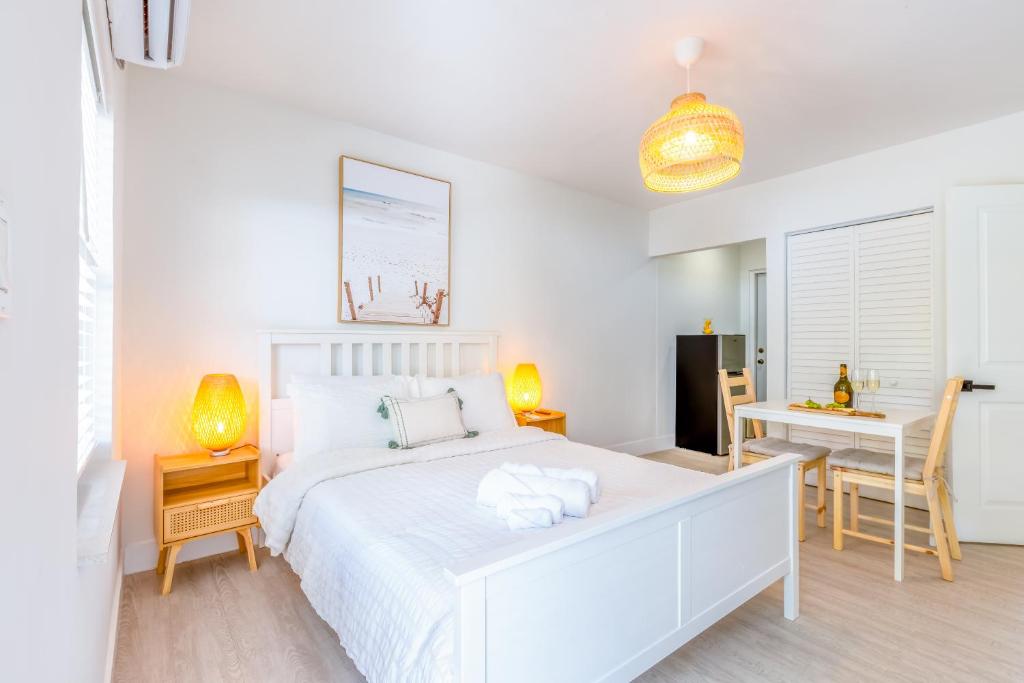 a white bedroom with a white bed and a desk at Casa Agave Miami in Miami