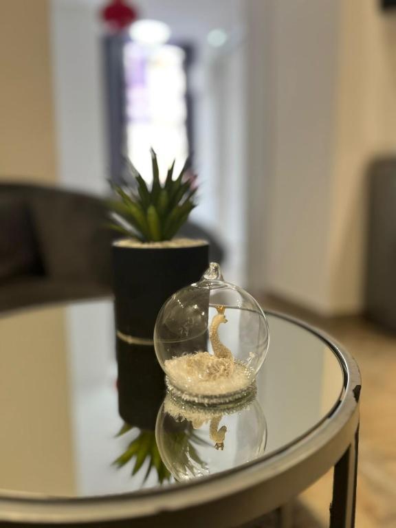un vase en verre avec un cygne sur une table en verre dans l'établissement Regal Apartment 2, à Tirana