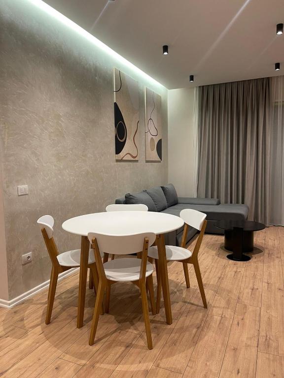 a dining room with a table and chairs and a couch at Comfort,excellence. in Kamëz