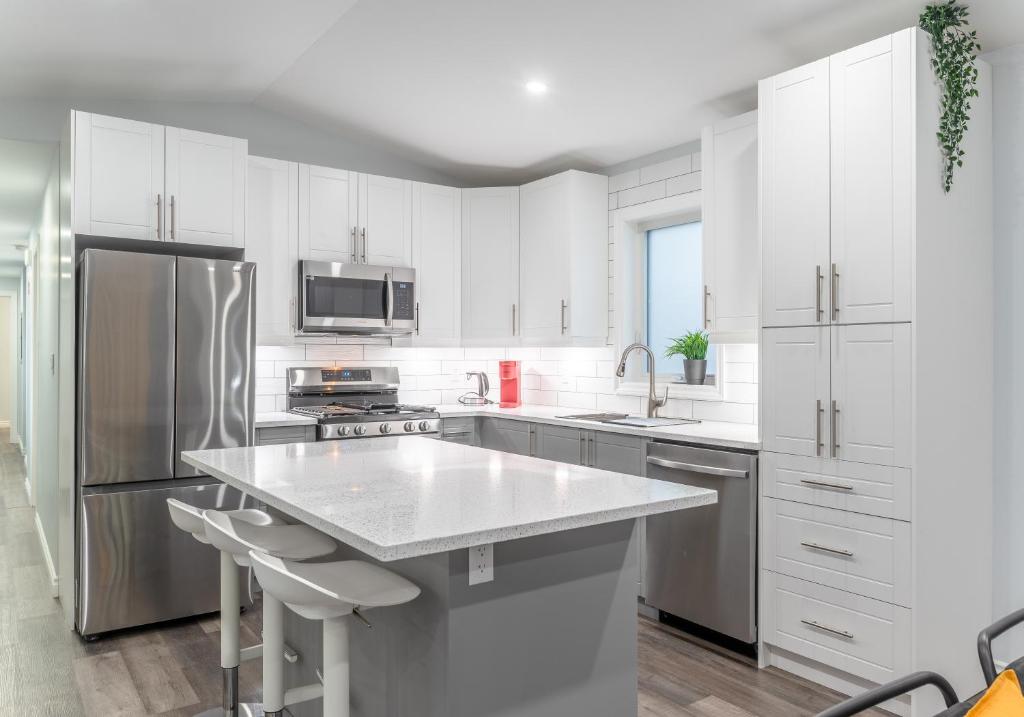 uma cozinha com armários brancos e um frigorífico de aço inoxidável em Centrally located 4Bedroom, 2Bath Home em Yellowknife