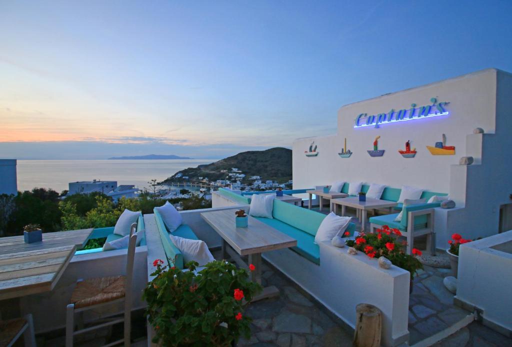 a restaurant with tables and chairs and a view of the ocean at Captain's in Kini