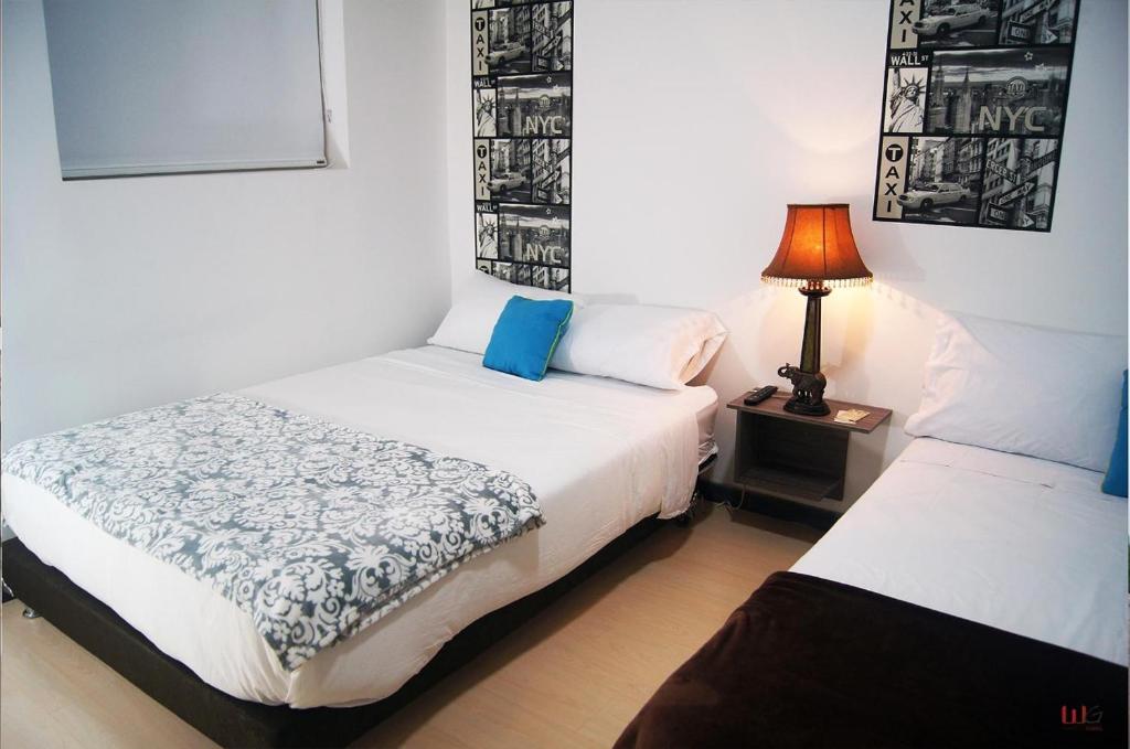 una camera con due letti e una lampada su un tavolo di HOTEL ALCUARA a Pereira