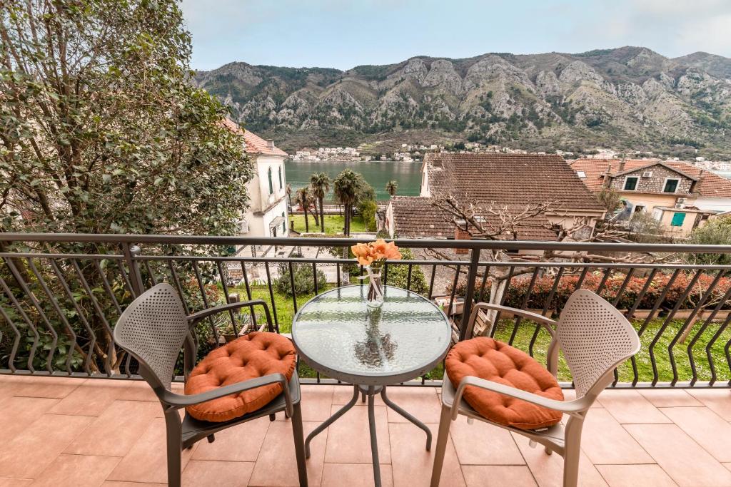 a table and chairs on a balcony with a view at Apartmani F&M in Kotor