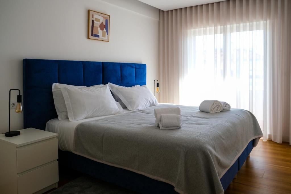 a bedroom with a large bed with two towels on it at Blue Dreams in Queluz