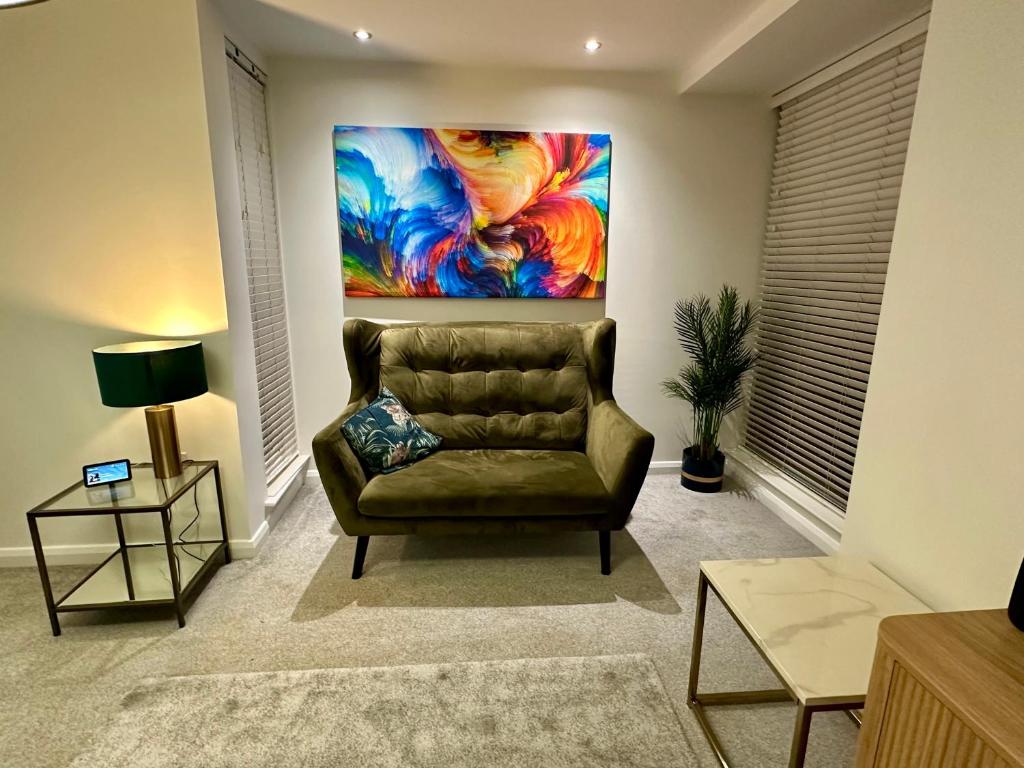 a living room with a couch and a painting on the wall at Central 3BR home in Manchester in Manchester