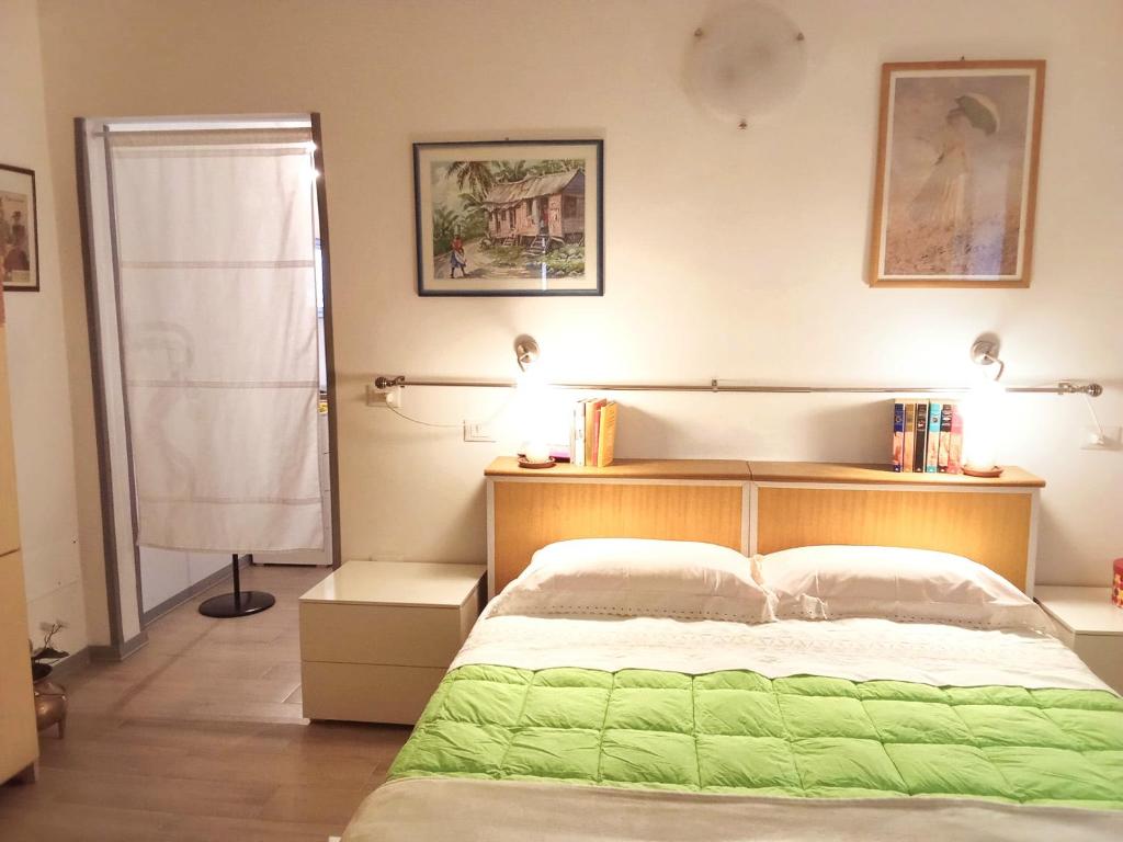 ein Schlafzimmer mit einem Bett mit einer grünen Decke in der Unterkunft L'approdo in Venedig