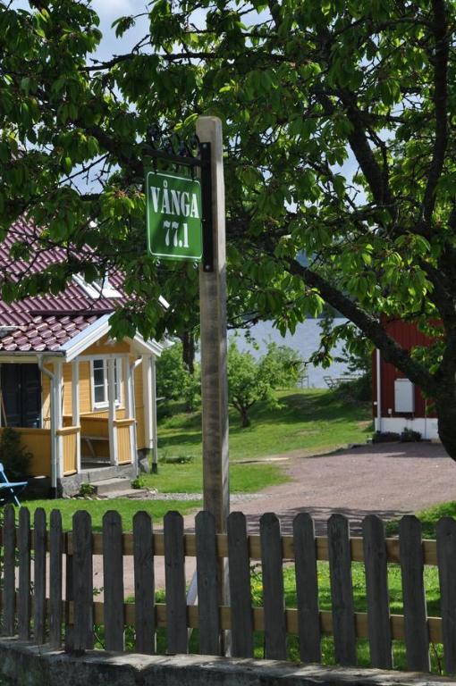 um sinal de rua num poste ao lado de uma cerca em Vånga 77.1 em Vånga