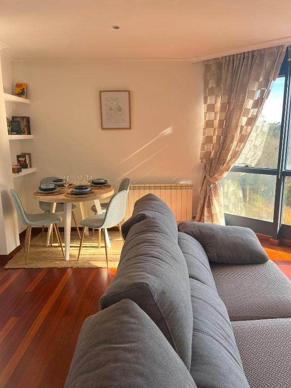 ein Wohnzimmer mit einem Sofa und einem Tisch in der Unterkunft Apartamento Boiro centro in Boiro