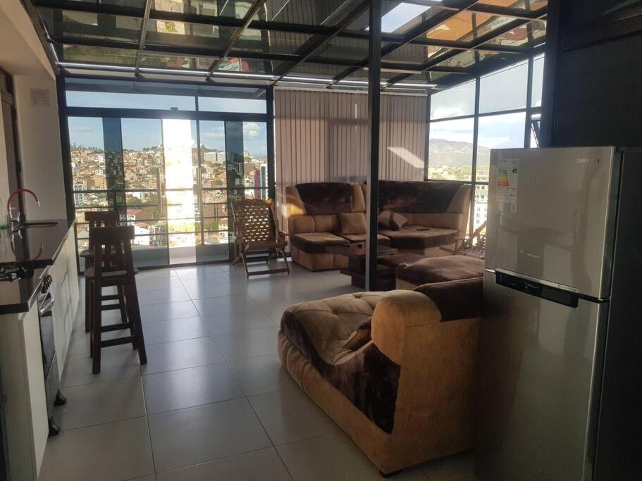 a living room with a couch in the middle of a kitchen at penthouse panorámico in Sucre