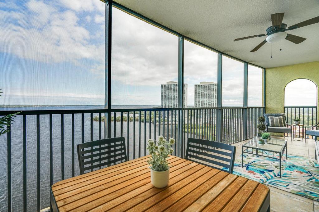 a large balcony with a wooden table and chairs at Riverfront Fort Myers Condo with Community Amenities in Fort Myers