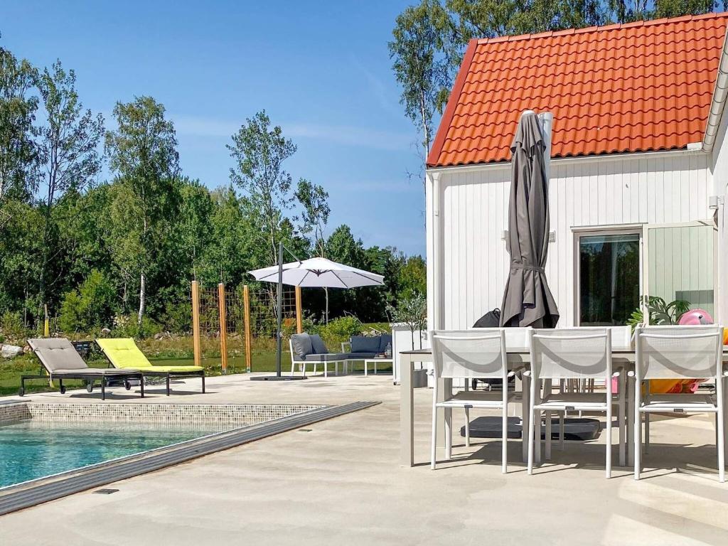 a patio with a table and chairs next to a pool at Holiday home Gotlands Tofta VII in Tofta