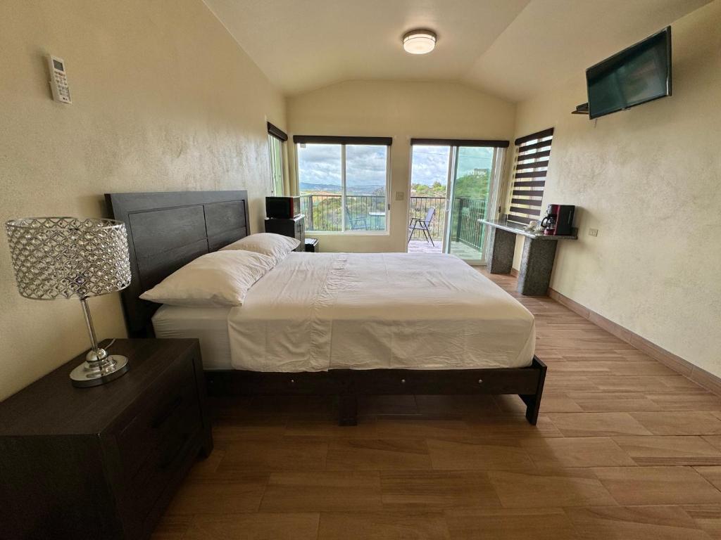 1 dormitorio con 1 cama con lámpara y balcón en Cabañas Colibri, en Valle de Guadalupe