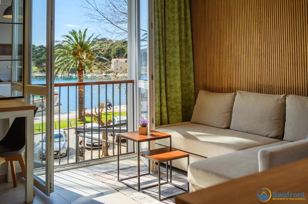 a living room with a couch and a large window at Seafront Residence Makarska in Makarska